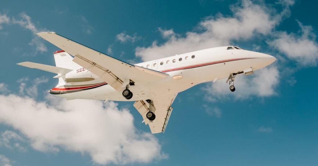 A sleek private jet captured mid-flight against a vibrant blue sky with scattered clouds.